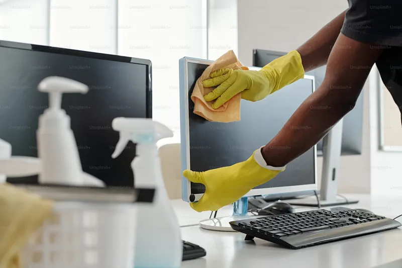 Technician cleaning a computer monitor screen